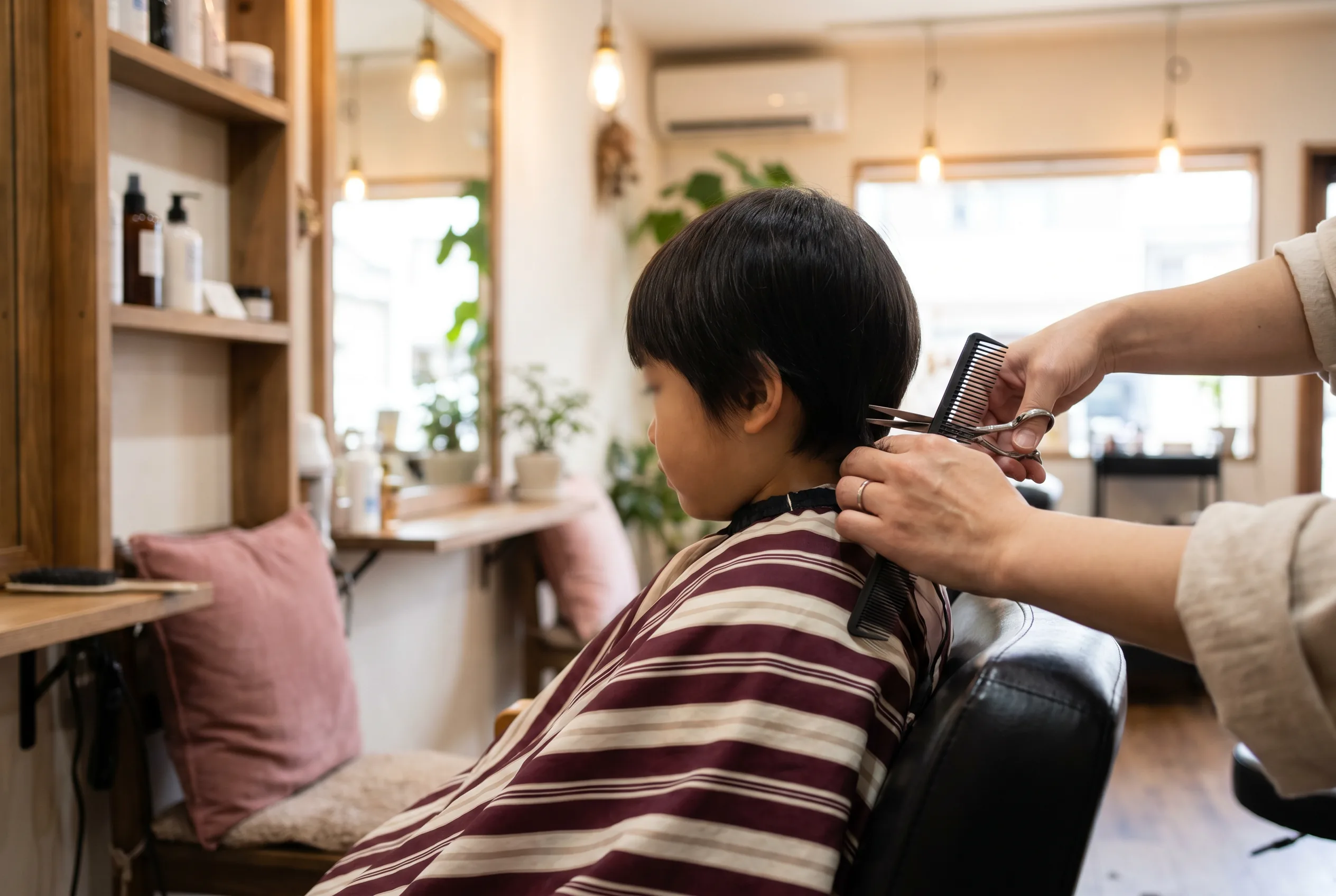 Peluquera cortando el pelo a un niño en Peluquería Dubón, Lucena